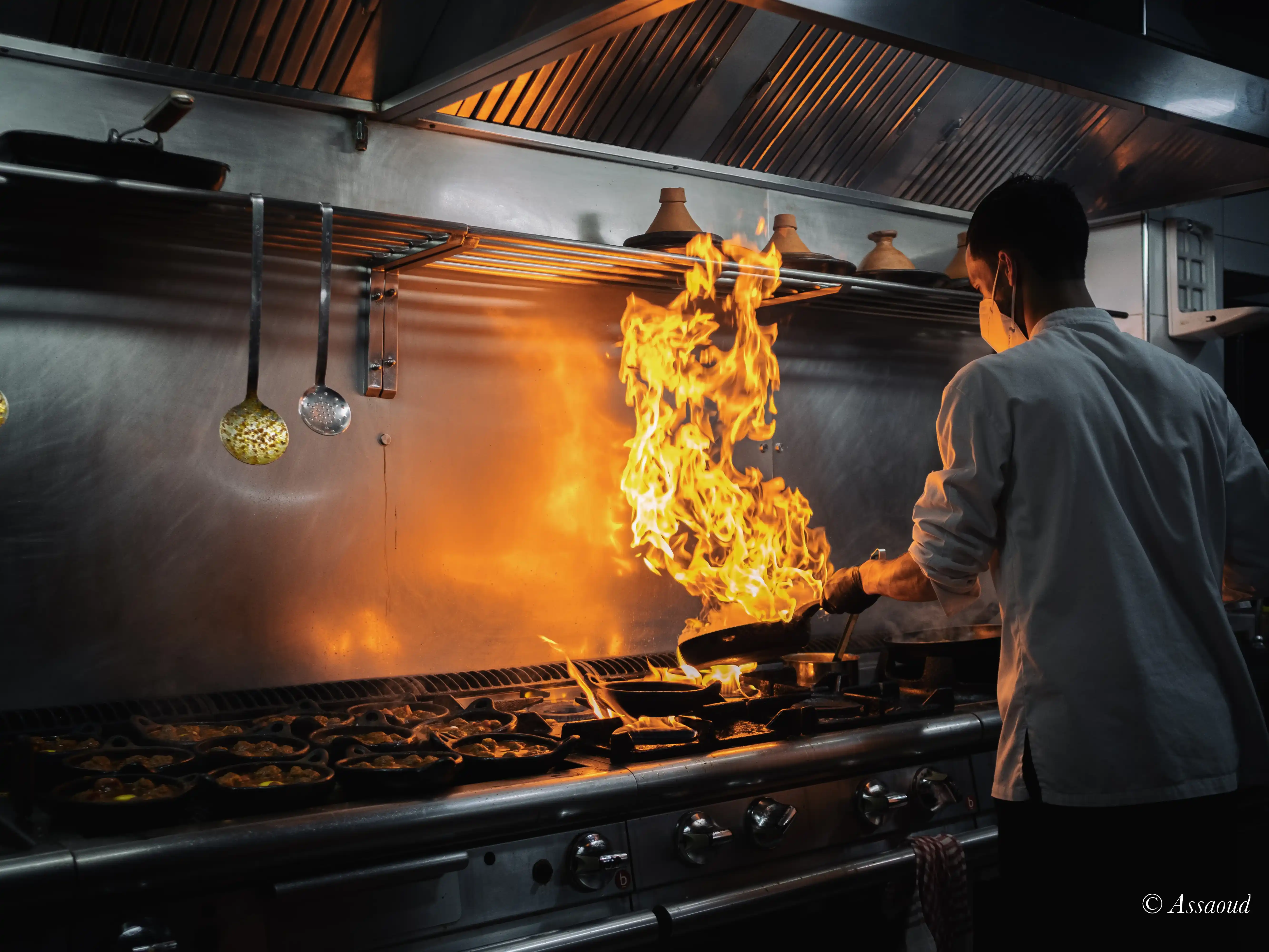 Chef cooking over open flames in the Triana kitchen in Chefchaouen